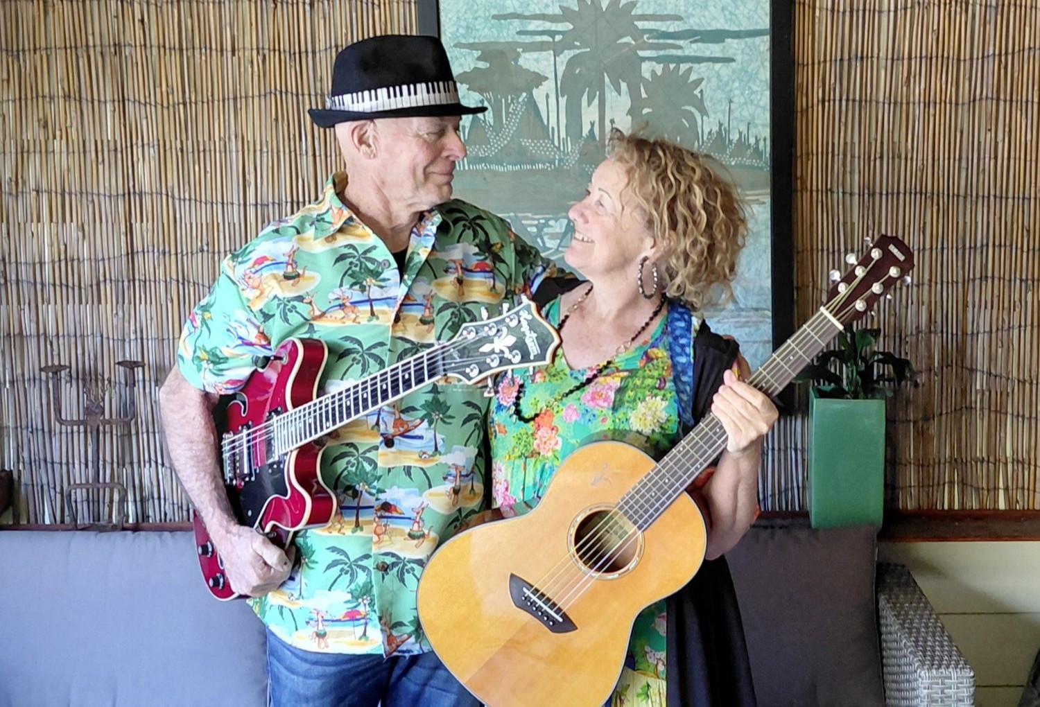 Man and woman looking at each other holding guitars